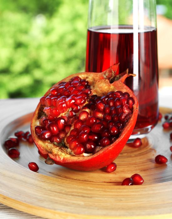 Fresh garnet juice with fruit on bright background